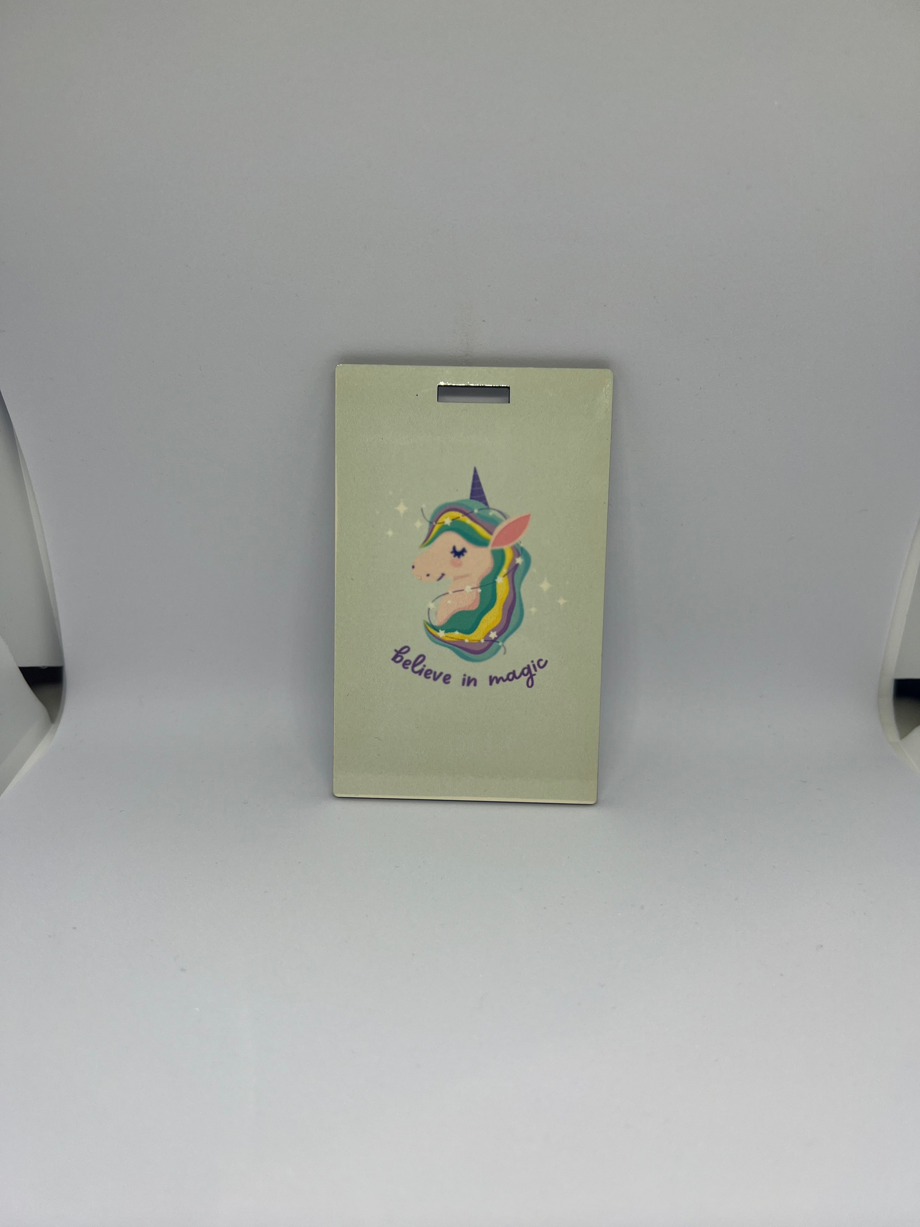 Believe in Magic unicorn luggage tag with rainbow mane illustration on cream background