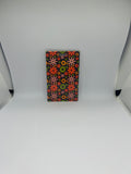 Retro floral luggage tag with colourful daisy pattern in pink orange green and yellow on dark background