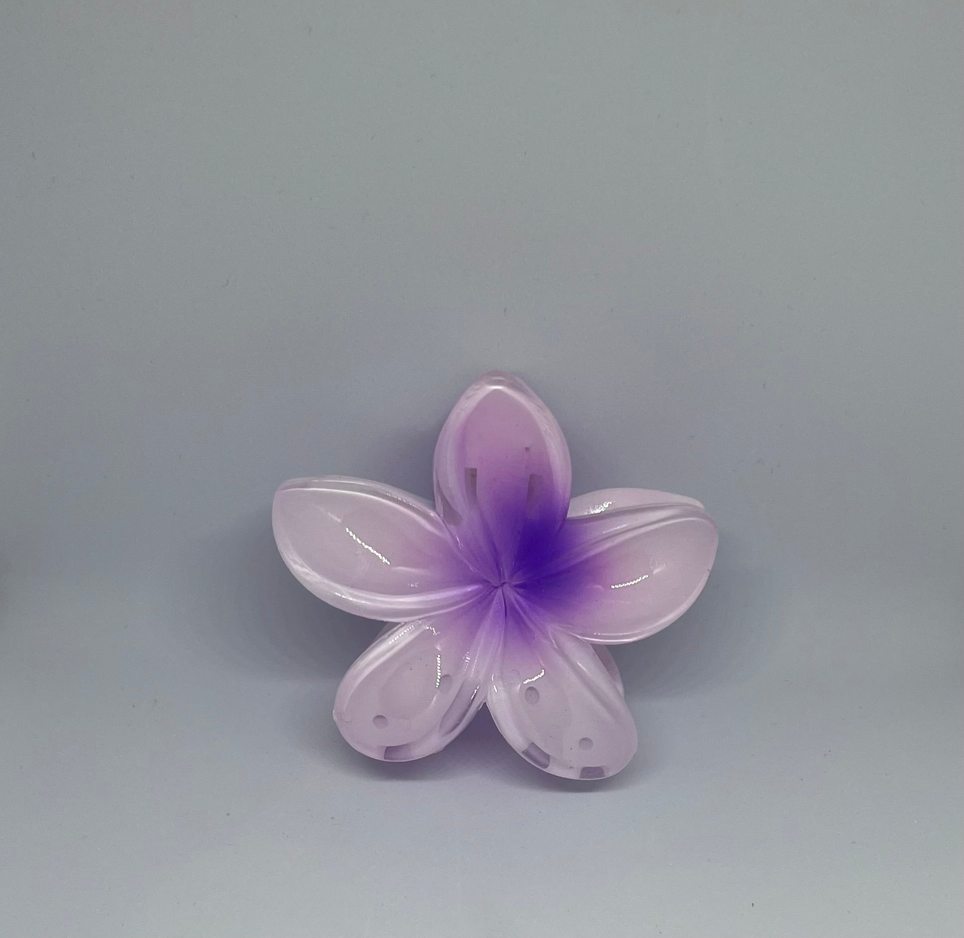 Purple frangipani flower hair claw clip with translucent lavender petals and deep violet centre