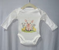 White long sleeve baby onesie with watercolour piglet lambs and chicks farm animals print on hanger