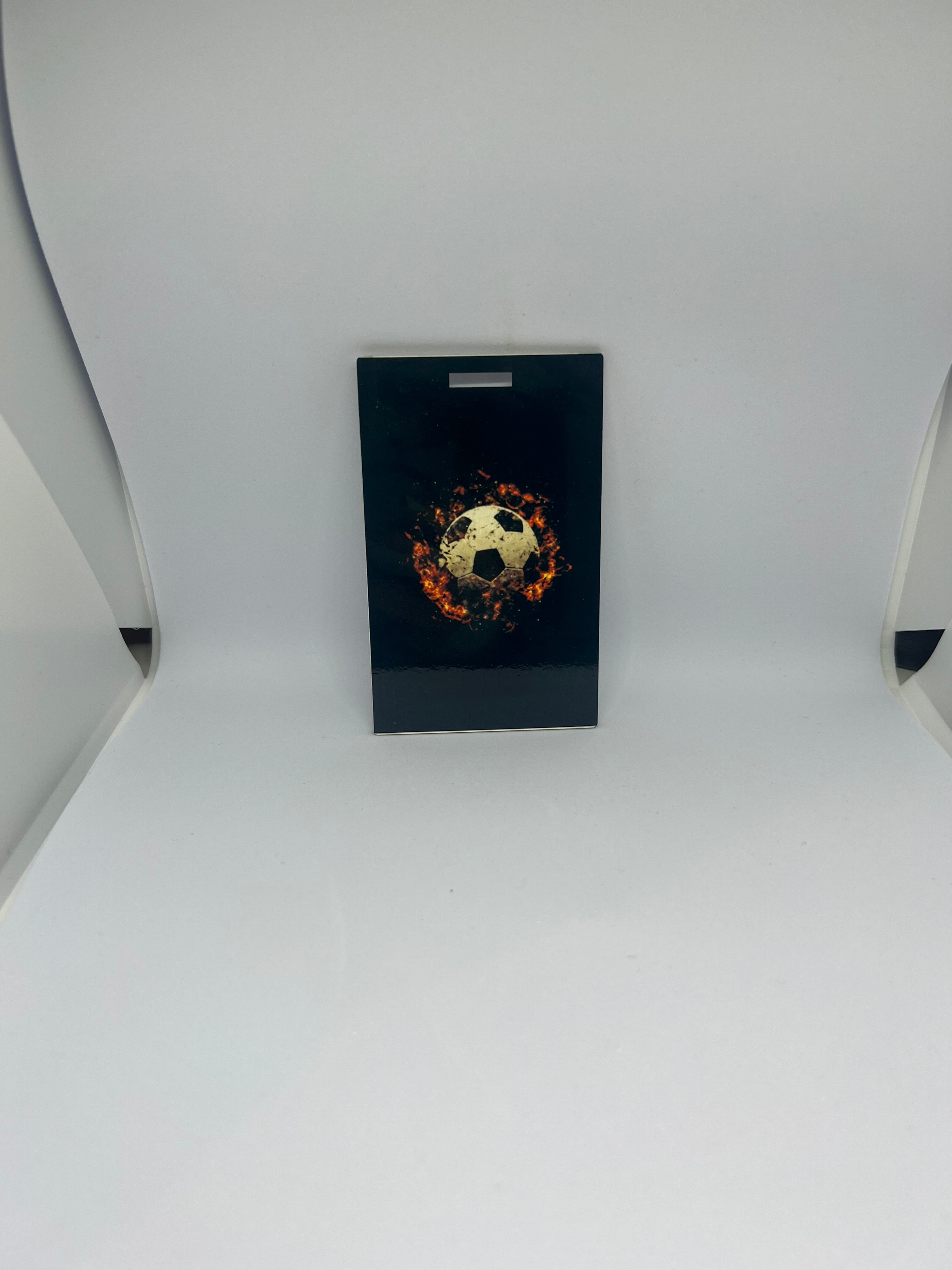 Flaming gold soccer ball luggage tag with fire and sparks on black background